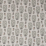 Detail of fabric in a small-scale floral print in shades of green, black and coral on a white field.