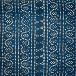 Detail of fabric in a dotted geometric stripe in cream on a navy field.