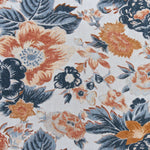 Detail of a linen fabric in a detailed floral pattern in shades of blue and orange on a cream field.