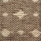 Close-up of a woven rug  with a diamond pattern in shades of cream on a brown field.