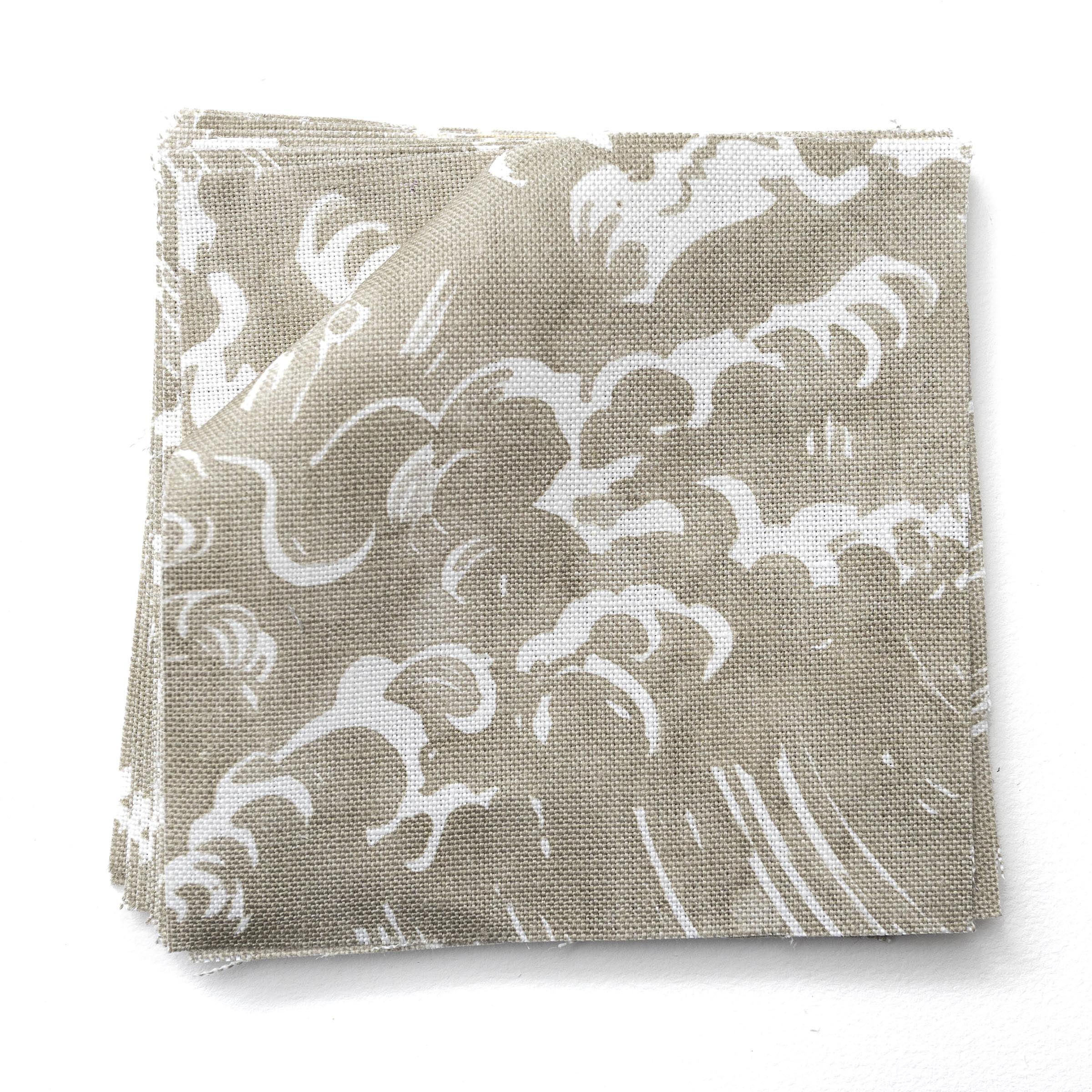 Fabric swatches in a playful wave print in white on a pale grey-green watercolor field.