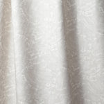 Draped linen in in a playful wave print in white on a pale grey watercolor field.