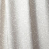 Draped linen in in a playful wave print in white on a pale grey watercolor field.
