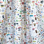Draped fabric yardage in a playful illustrated "stuff" print in multicolor pastels on a white field.