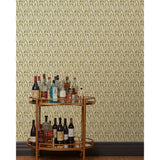 A bronze bar cart in front of a wall papered in an abstract tulip print in a repeating stripe on a sage field.