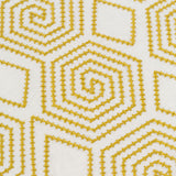Detail of fabric with a playful embroidered geometric grid print in mustard on a white field.