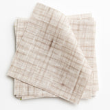 A stack of fabric swatches in a textured tweed pattern in shades of cream and brown.