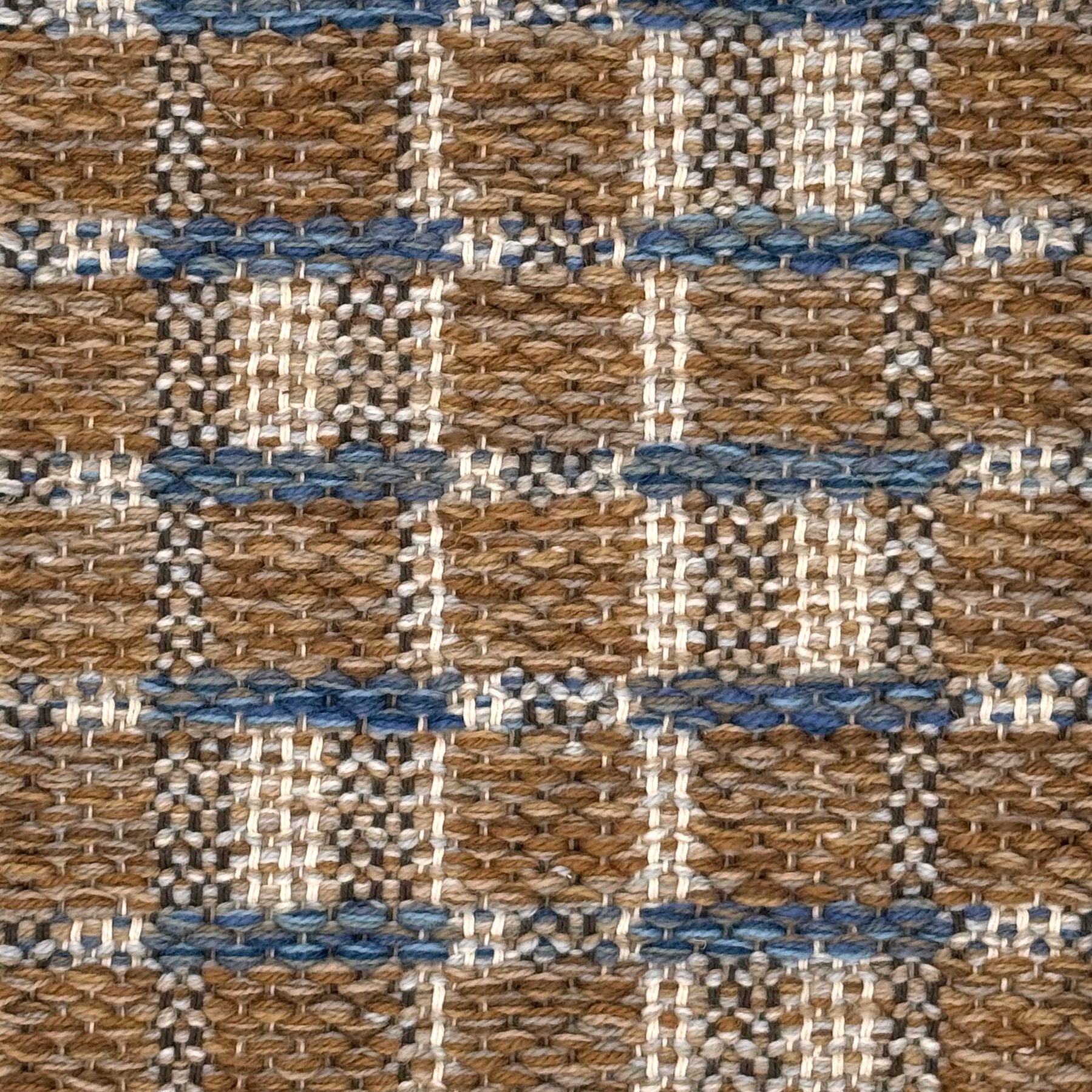 A close-up of a woven rug featuring a brown and beige plaid design with blue accents.