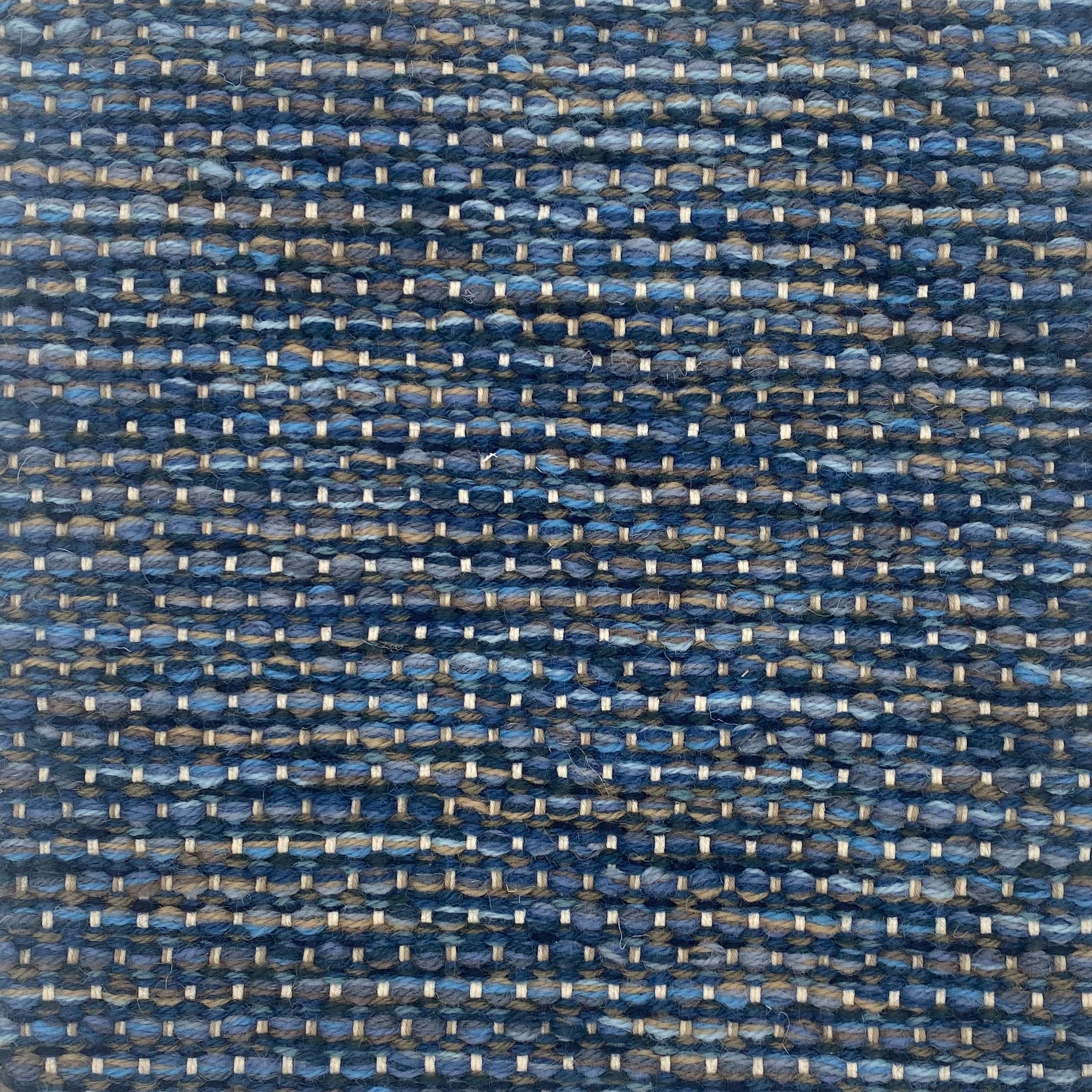 Textured handwoven carpet with a mix of blue colors. 