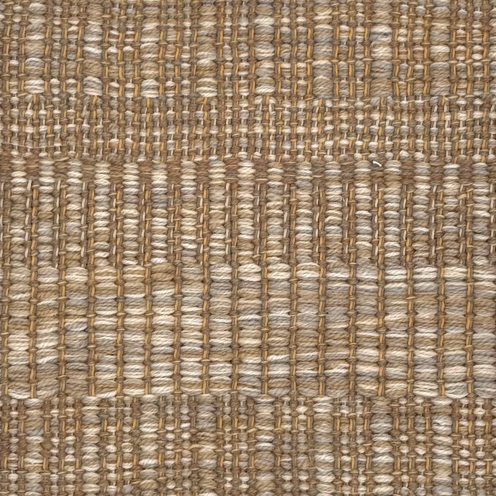 A close-up of a woven rug with a subtle stripe pattern in shades of taupe and tan. 