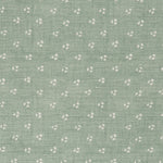 Detail of a linen fabric in a clustered dot pattern in cream on a sage field.