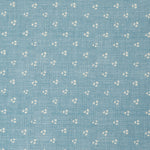 Detail of a linen fabric in a clustered dot pattern in cream on a sky blue field.