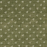 Detail of a linen fabric in a clustered dot pattern in cream on a moss field.