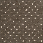 Detail of a linen fabric in a clustered dot pattern in beige on a dark gray field.