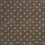 Detail of a linen fabric in a clustered dot pattern in beige on a dark gray field.