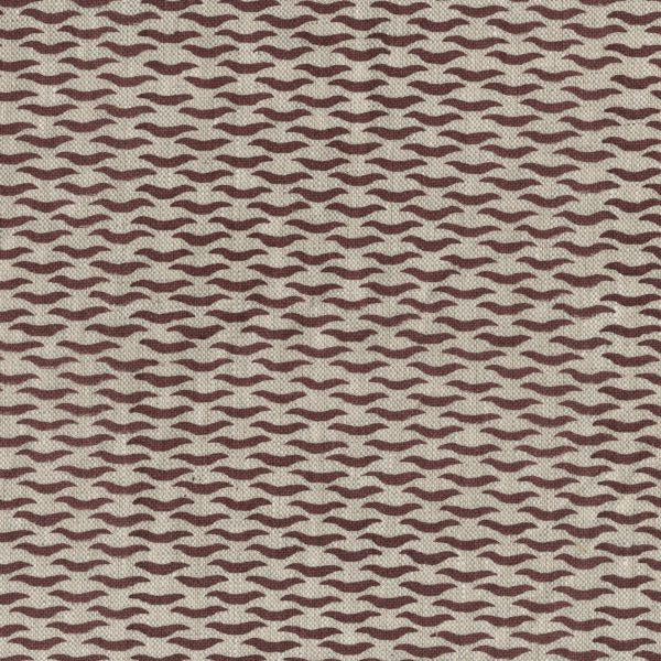 Fabric in a repeating abstract print in maroon on a tan field.