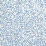 Detail of fabric in a dense paisley print in white on a light blue field.