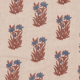 Detail of fabric in a repeating floral grid in blue and rust on a cream field.