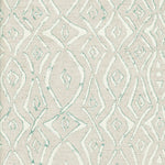 Detail of fabric in a painterly geometric grid in white with turquoise accents on a cream field.