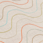 Detail of fabric with an embroidered undulating stripe pattern in shades of yellow, red and blue on a cream field.