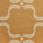 Detail of fabric in a leafy lattice print in cream on a burnt orange field.