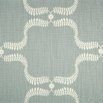 Detail of fabric in a leafy lattice print in cream on a blue-gray field.