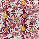 Printed linen in a hand drawn daisy design in shades of red, pink and yellow with sage leaves on a crimson field.