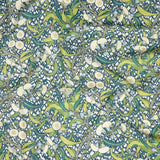 Draped fabric in a dense floral print in yellow, green and navy on a cream field.