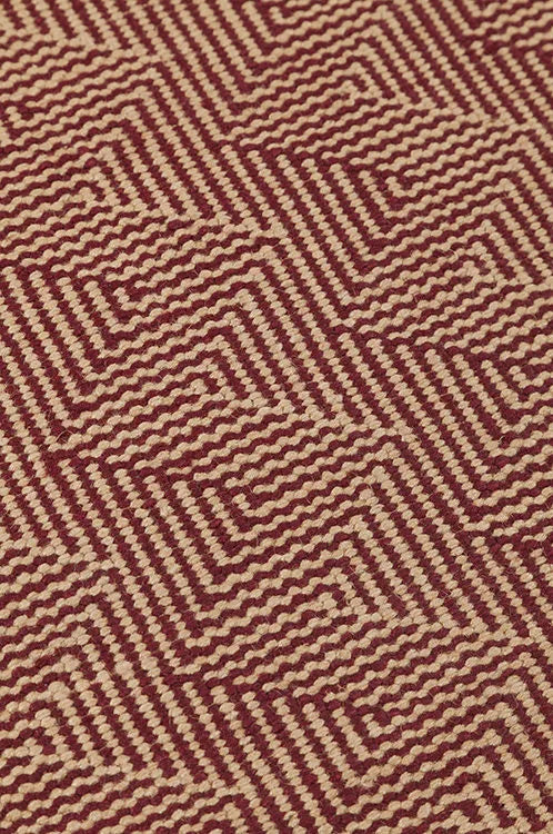 Patterned fabric with a zigzag design in red and beige.