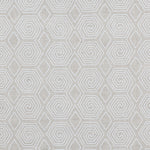 Fabric with a playful embroidered geometric grid print in white on a cream field.