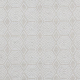 Fabric with a playful embroidered geometric grid print in white on a cream field.