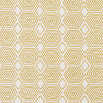 Fabric with a playful embroidered geometric spiral print in mustard on a white field.