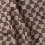 Detail of gently draped printed fabric in a watercolor ikat-inspired checkerboard pattern in tonal warm clay brown. 