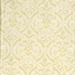 Detail of fabric in a botanical damask print in tan on a cream field.