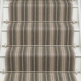 Striped flatweave runner in tan and black and white on white staircase