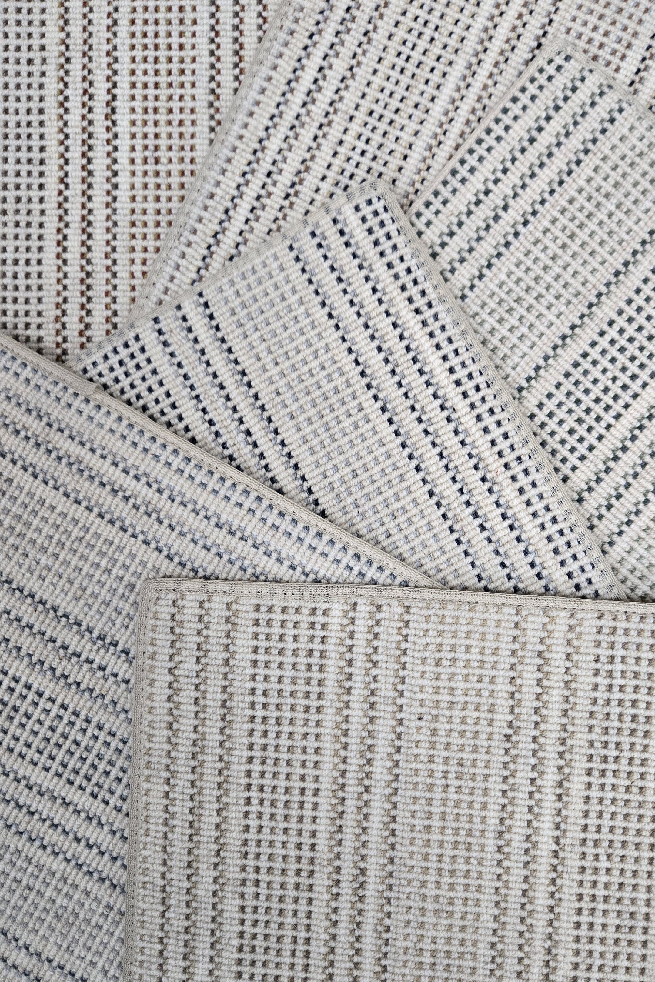 Broadloom carpet samples in a stripe pattern in a range of neutral colors. 