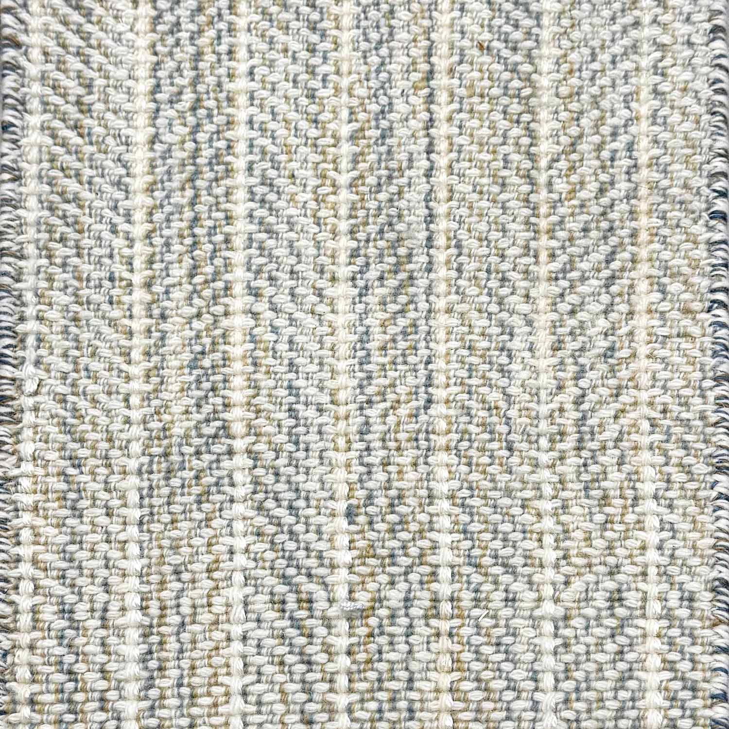 Close up of broadloom carpet with striated herringbone weave in white with accents of blue and green. 