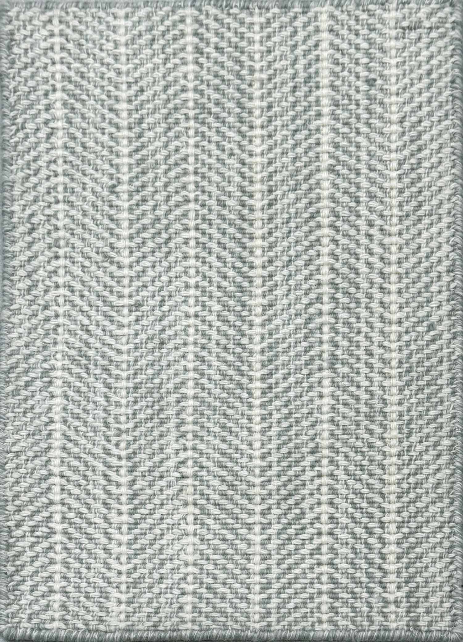 Close up of broadloom carpet with striated herringbone weave in white with accents of slate blue.