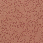 Detail of a wabric with an abstract embroidered pattern in clay pink on a clay pink field.
