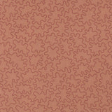 Fabric with an abstract embroidered pattern in clay pink on a clay pink field.