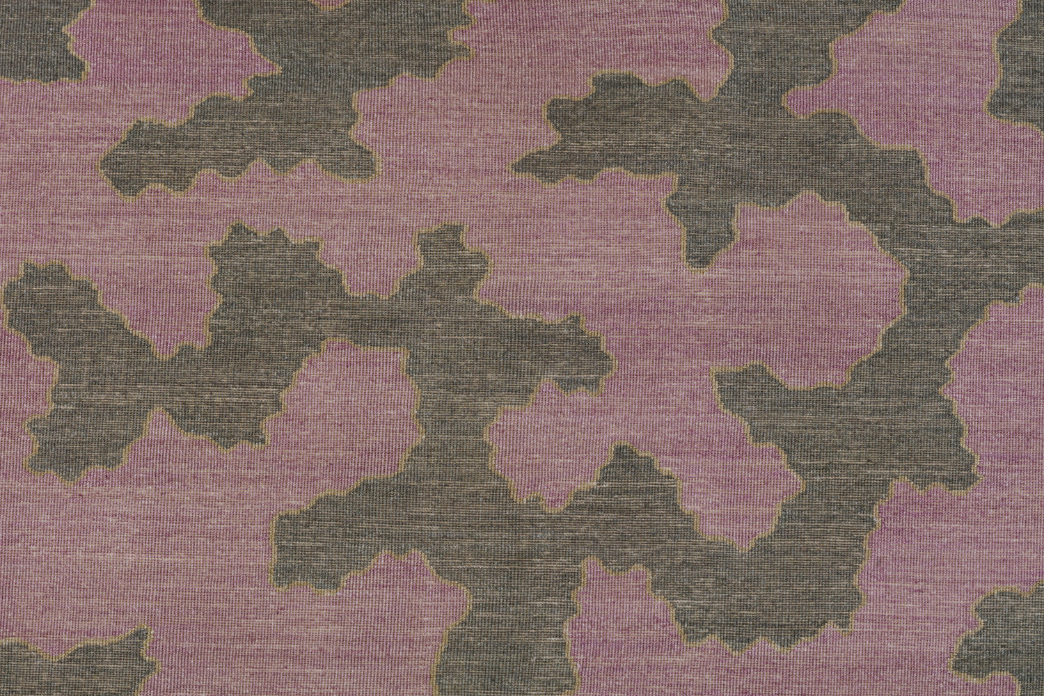 Detail of a handwoven rug in an abstract coral design grey and purple with a tan accent line. 