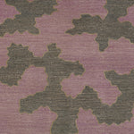 Detail of a handwoven rug in an abstract coral design grey and purple with a tan accent line. 