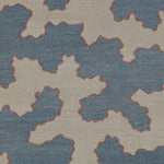 Detail of a handwoven rug in an abstract coral design in blue and white with a red accent.