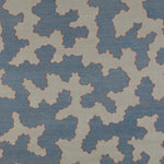 Detail of a handwoven rug in an abstract coral design in blue and white with a red accent.