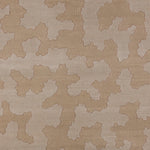 Detail of a handwoven rug in an abstract coral design in tonal shades of tan and taupe. 