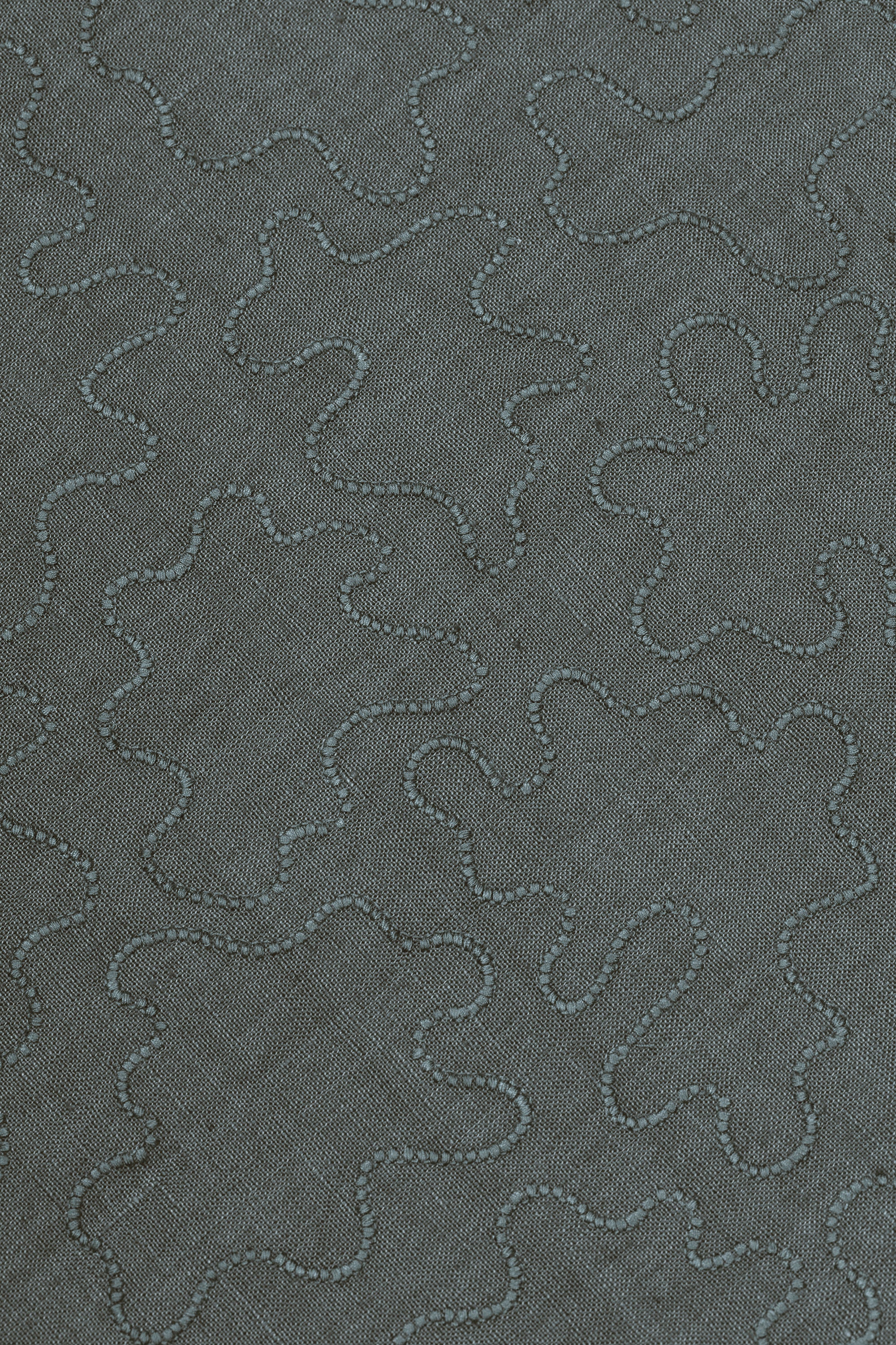 Fabric with an abstract embroidered pattern in gray on a gray field.