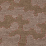 Detail of a handwoven rug in an abstract coral design brown and lavender with a pink accent line. 