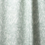 Draped linen in  an abstract leaf pattern in white on a pale aqua watercolor field.