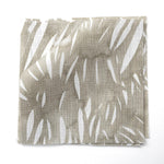 Fabric swatches in an abstract leaf pattern in white on a taupe grey watercolor field.