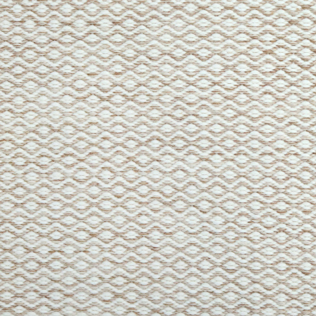 Flatweave rug in a small scale zigzag dot stripe in cream on a warm beige field.